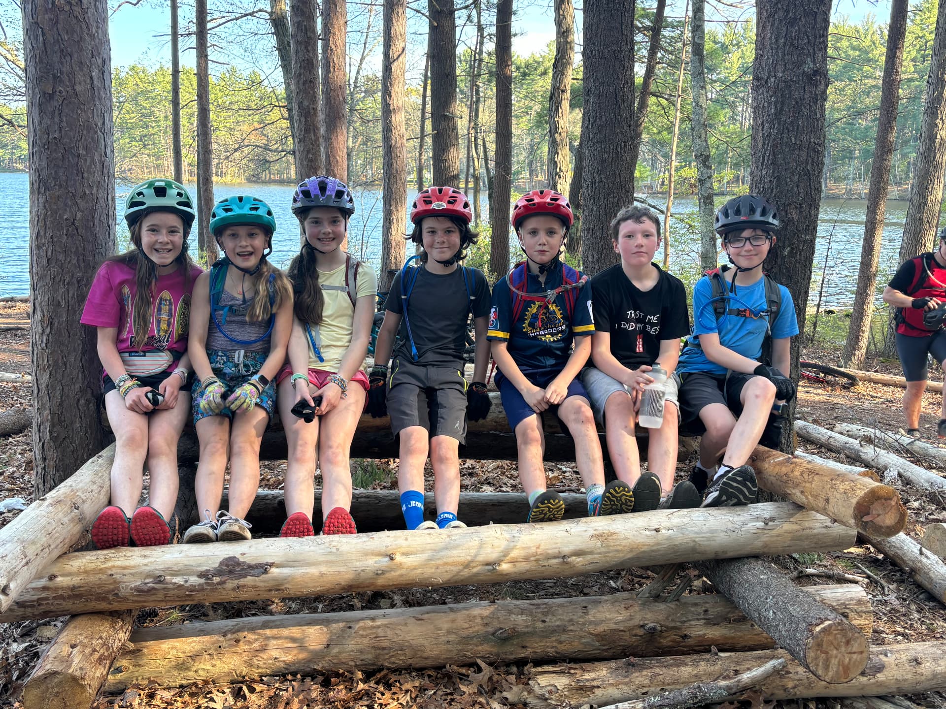 Shredders riders sitting together on a log by the lake