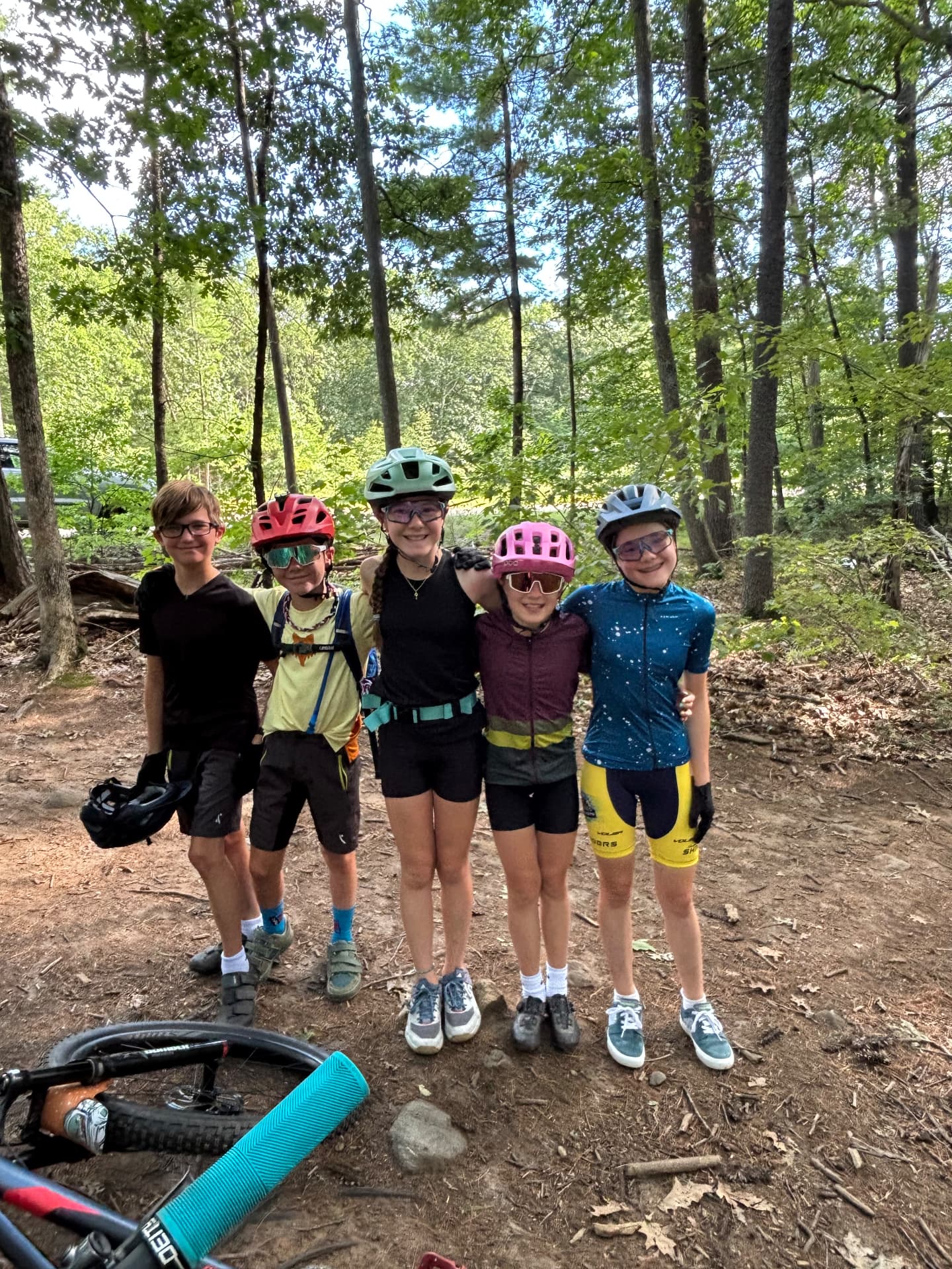 Five smiling Shredders riders with their bikes on the trail