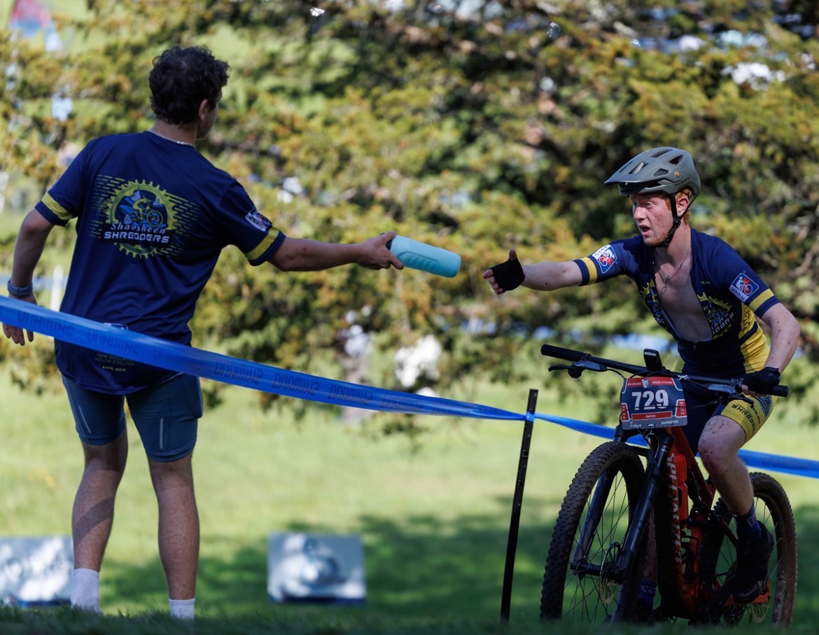A Shredders rider grabbing a bottle in the feed zone